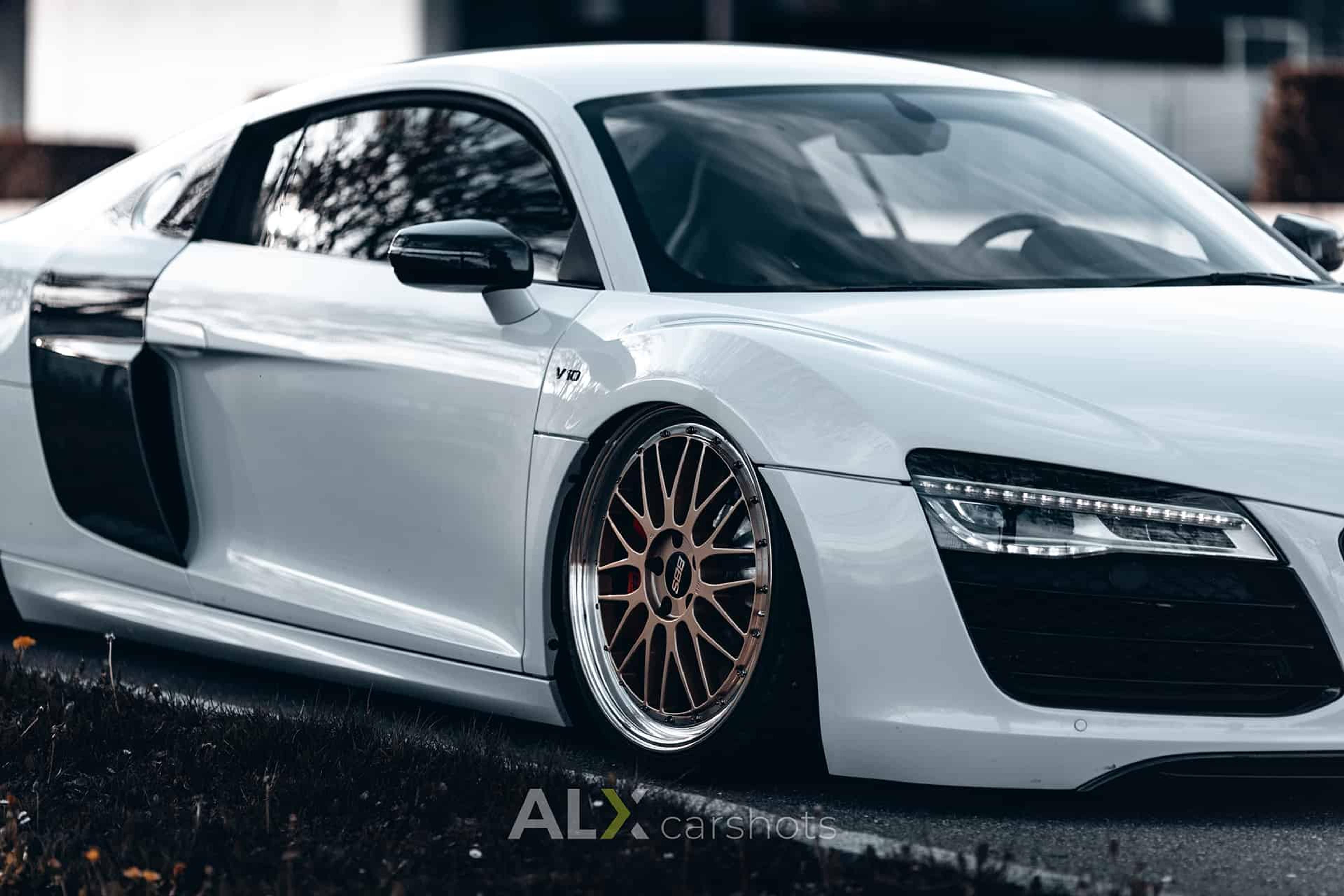 Tiefergelegter weißer Audi R8 mit Luftfahrwerk und bronzefarbenen Felgen am Bodensee
