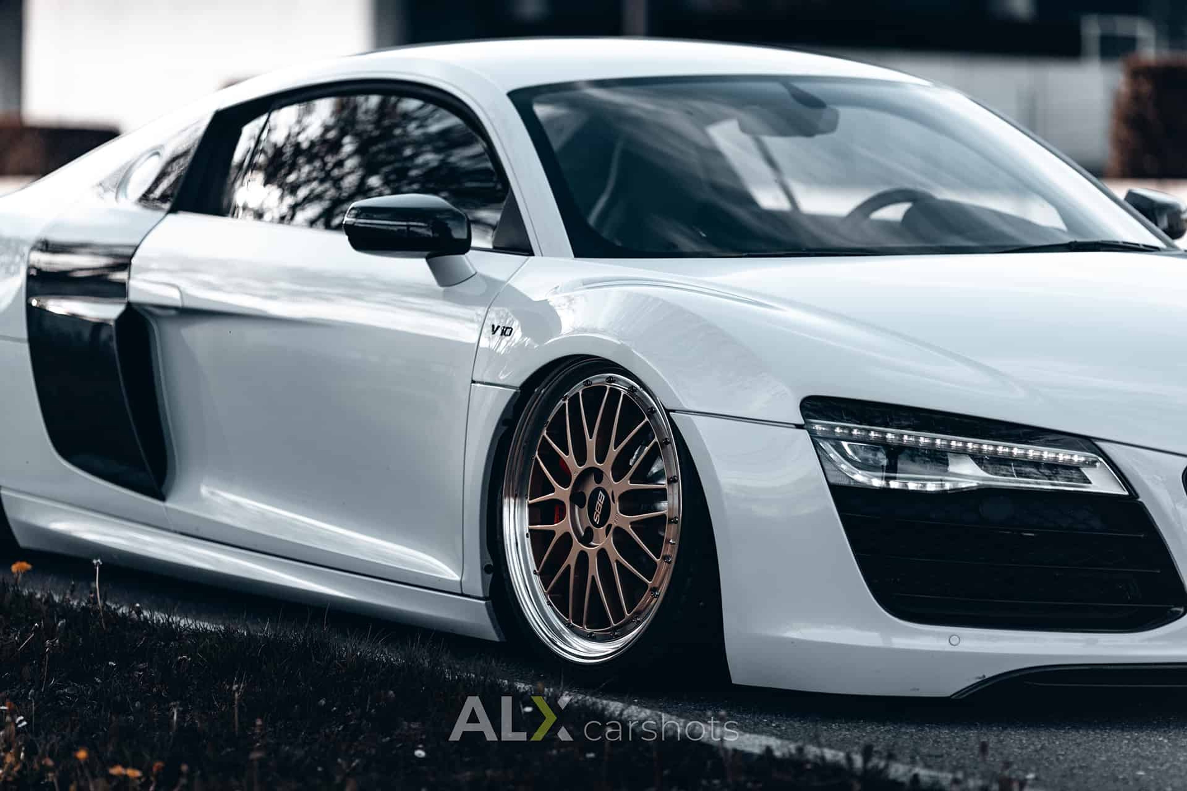 Tiefergelegter weißer Audi R8 mit Luftfahrwerk und bronzefarbenen Felgen am Bodensee