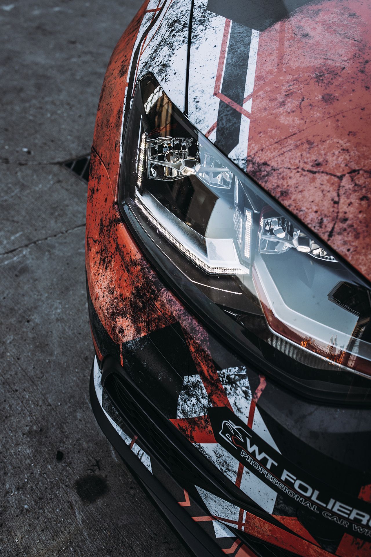 Scheinwerfer und Front des schwarz-rot-weiß folierten VW Polo GTI im Detail
