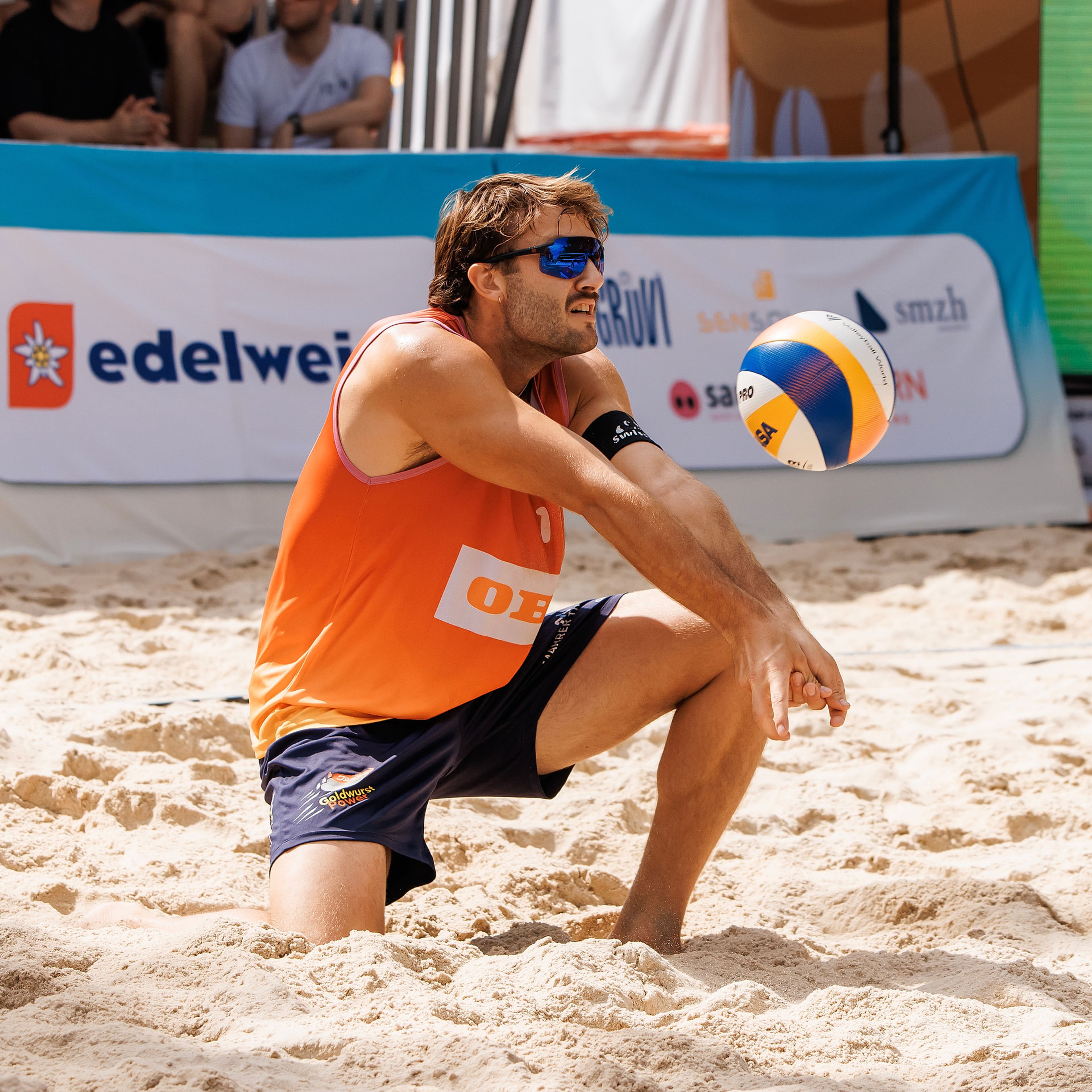 Leo Dillier nimmt den Ball tief im Bagger an, vor gut besetzter Tribüne im Spiel Dillier/Flückiger gegen Džavoronok/Hadrava bei der OBI Beach Tour 2026 in Luzern.