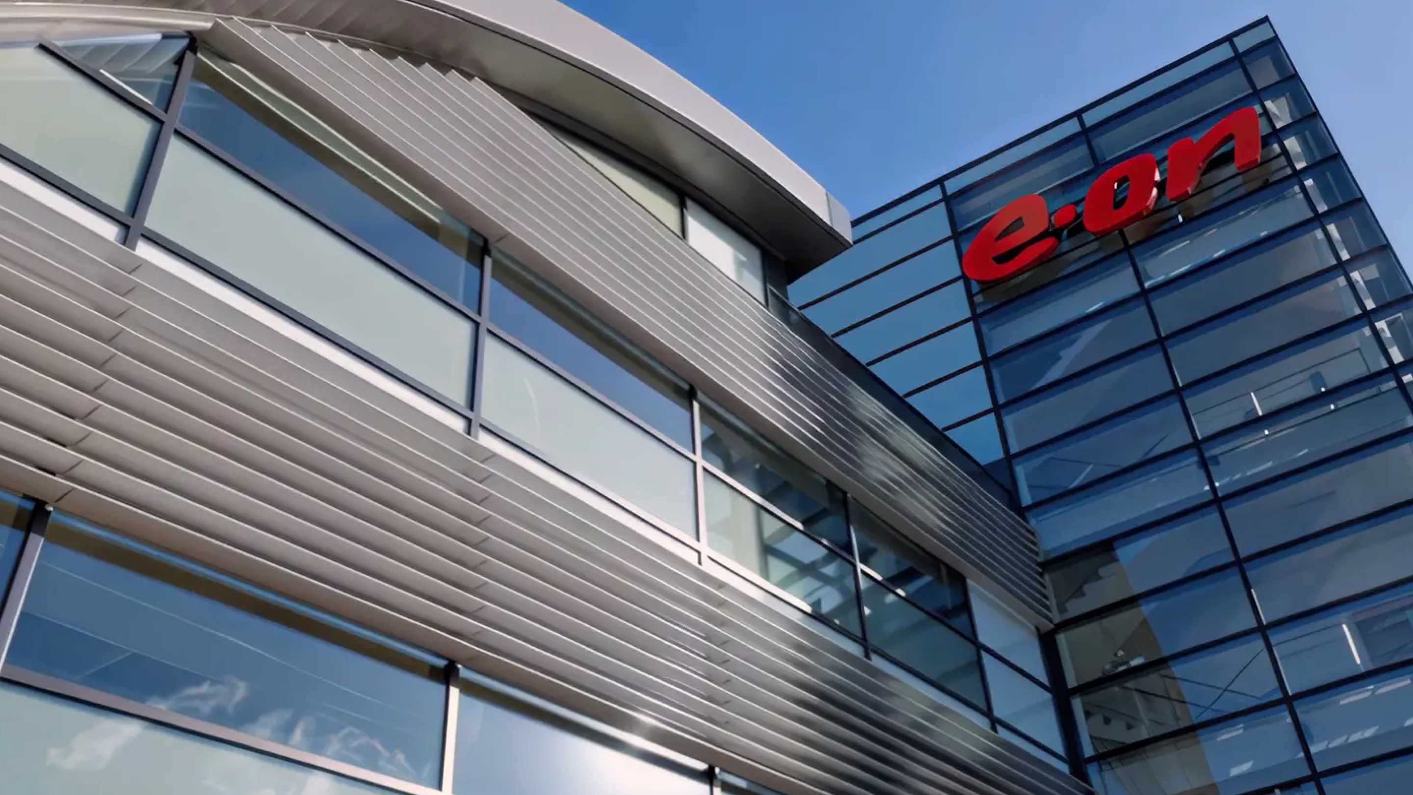 A modern office building with glass walls and the red 'e.on' logo.