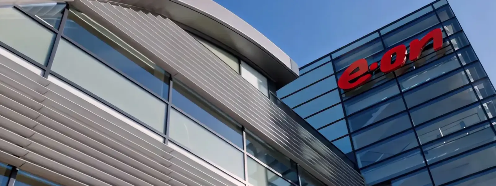A modern office building with glass walls and the red 'e.on' logo.