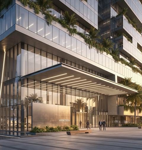 Modern glass building with green terraces and a prominent, illuminated entrance.
