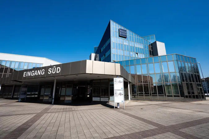 Modern glass building of Messe Essen with "Eingang Süd" (South Entrance) sign.