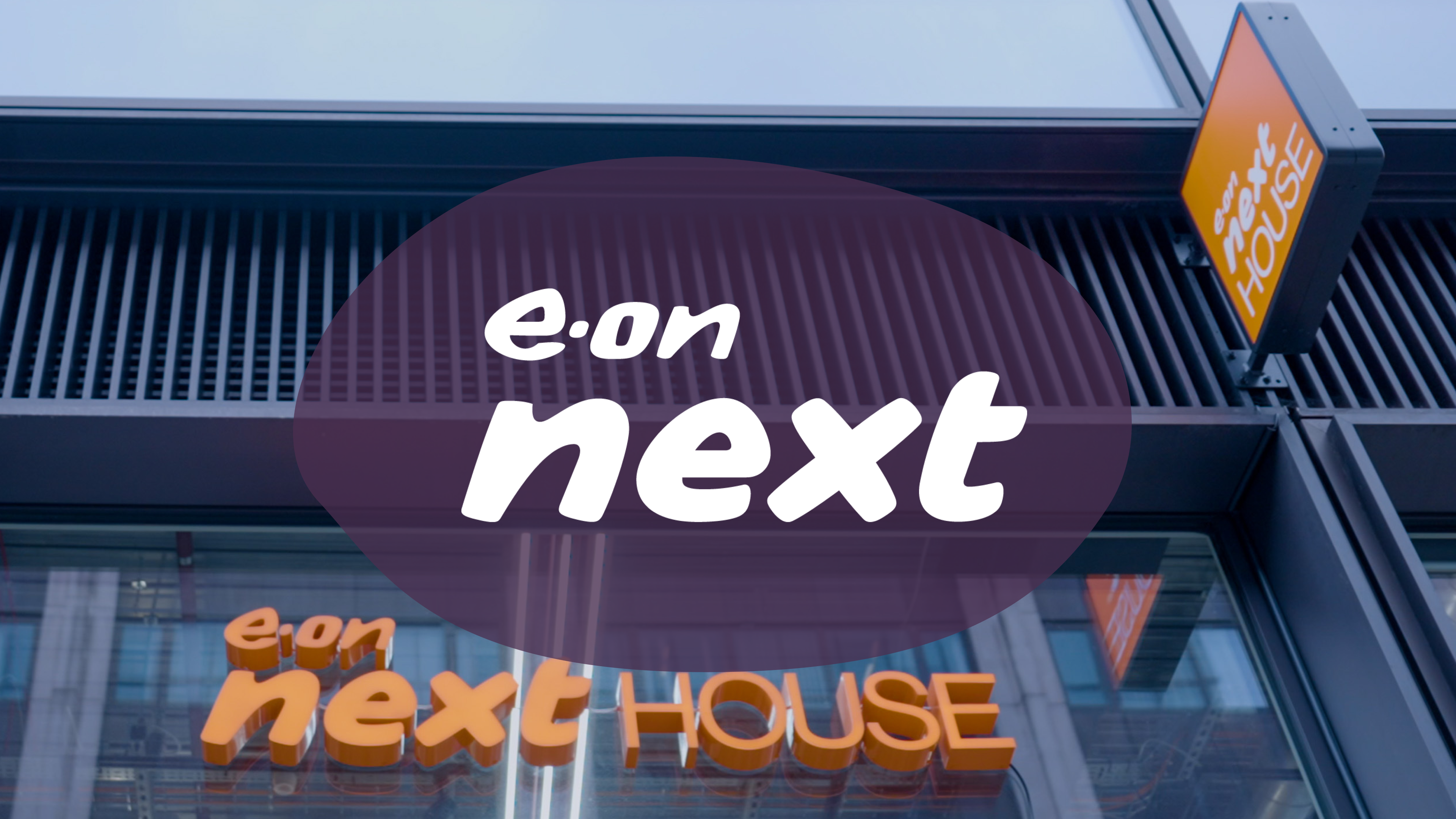 "e.on next HOUSE" signage on a building exterior with an "e.on next" logo overlay.