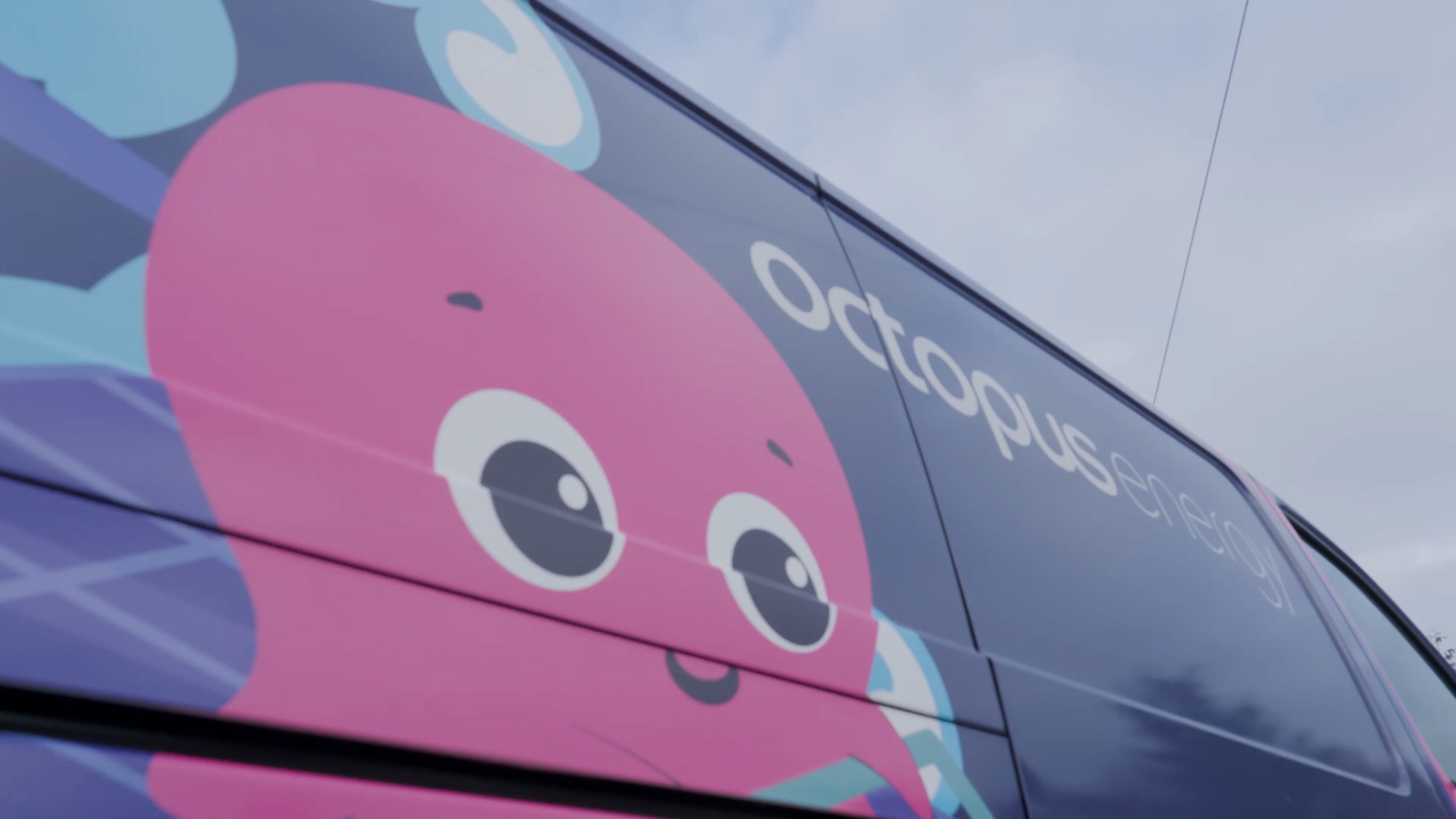 Side of a dark vehicle featuring a pink cartoon octopus and "Octopus energy" text.