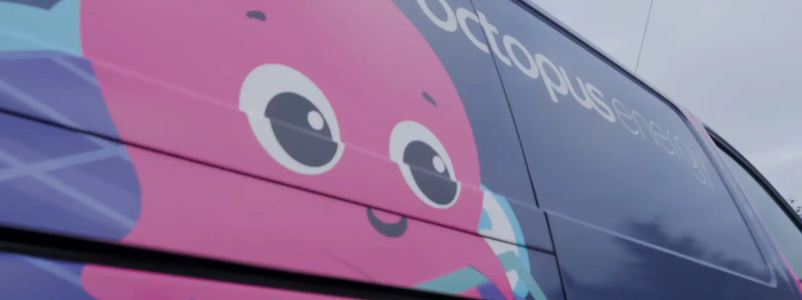 Side of a dark vehicle featuring a pink cartoon octopus and "Octopus energy" text.