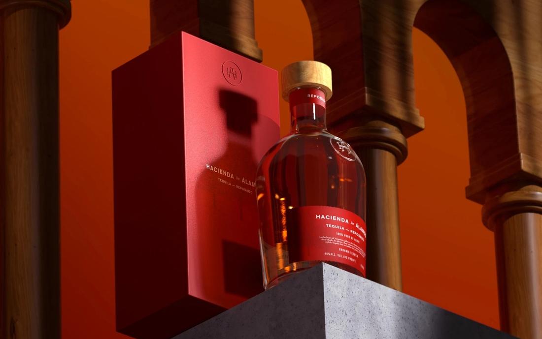 Botella y caja roja de tequila Hacienda los Álamos entre arcos de madera