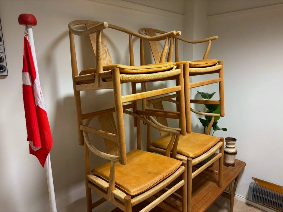 Stolene stablet to og to på et teakbord på lageret.