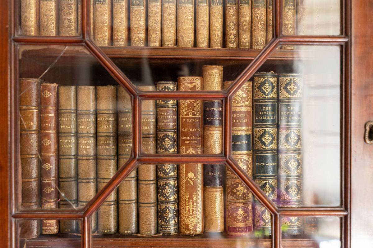Chambre aux Fleurs: leather-bound books behind the glazed doors of a bookcase