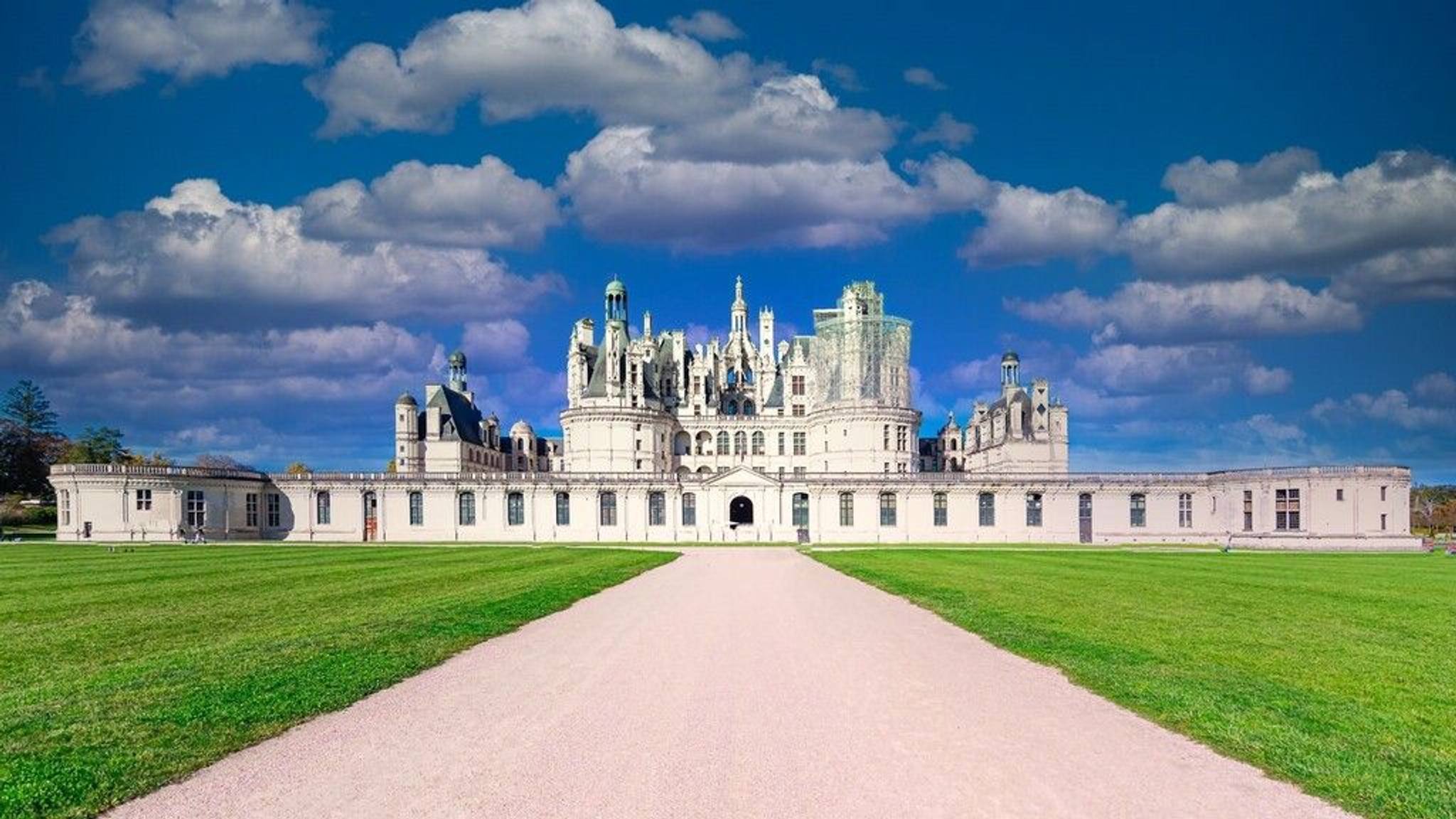Le château de Chambord et ses pelouses au bout d'une allée droite