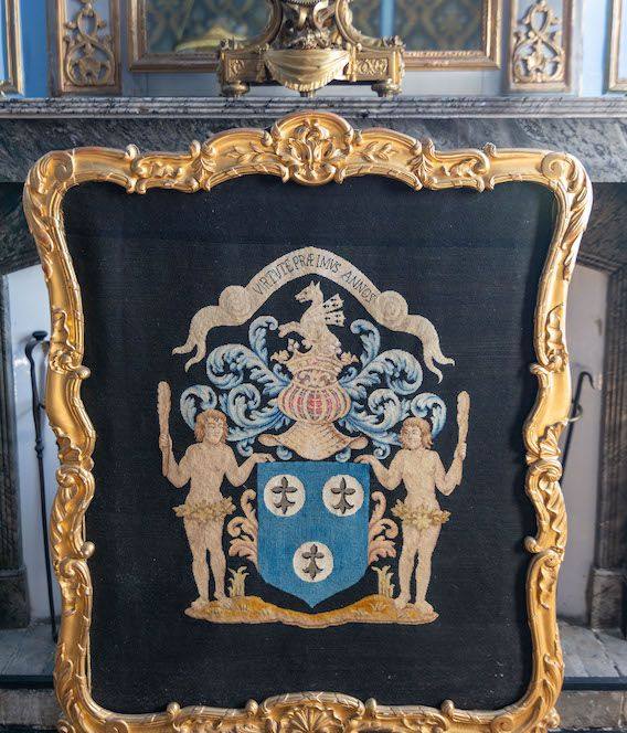 Ofenschirm im Goldrahmen mit gesticktem Wappen und zwei Schildhaltern