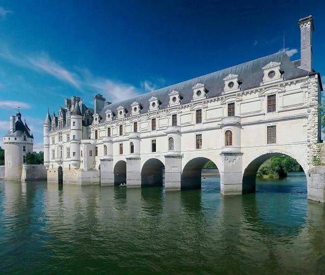 Le château de Chenonceau et sa galerie à arches enjambant le Cher, sous un ciel bleu