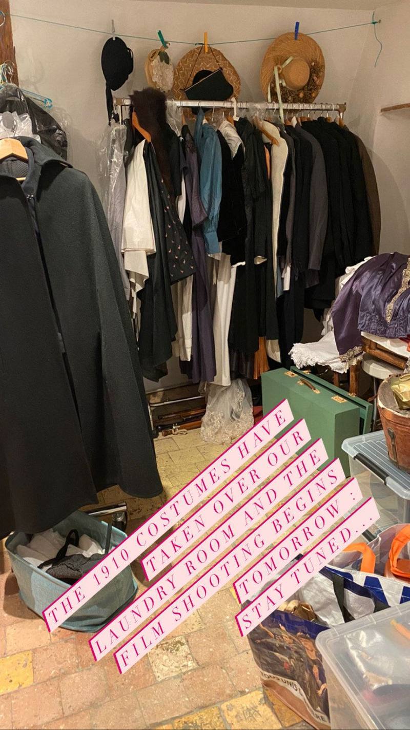 Rack of 1910 period costumes in the laundry room, captioned: the film shoot begins tomorrow