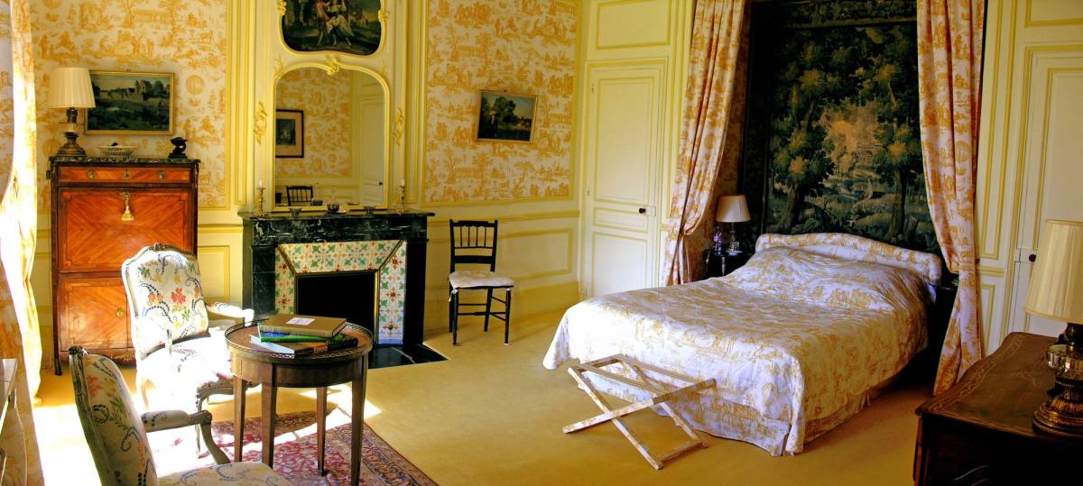 Chambre Jaune: canopy bed before a tapestry, yellow toile de Jouy walls and marble fireplace