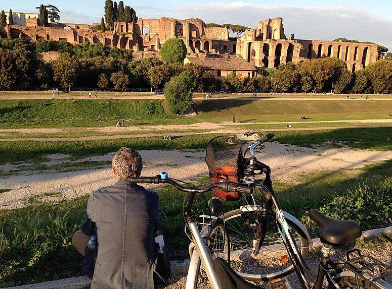 Un homme se repose près des vélos face au Circus Maximus et aux ruines du Palatin, à Rome