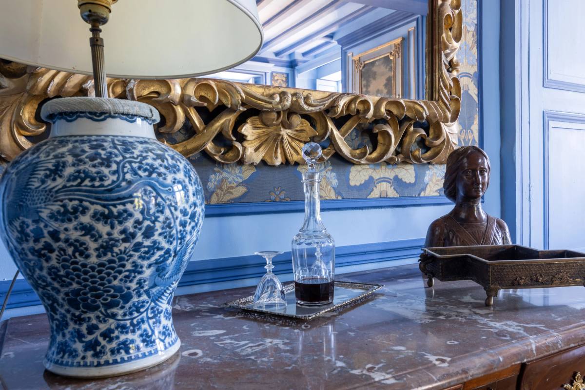 Blue-and-white porcelain lamp, port decanter and small carved bust on a marble top