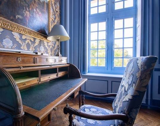 Roll-top desk and damask armchair by a tall window, Chambre Marin de Vanssay