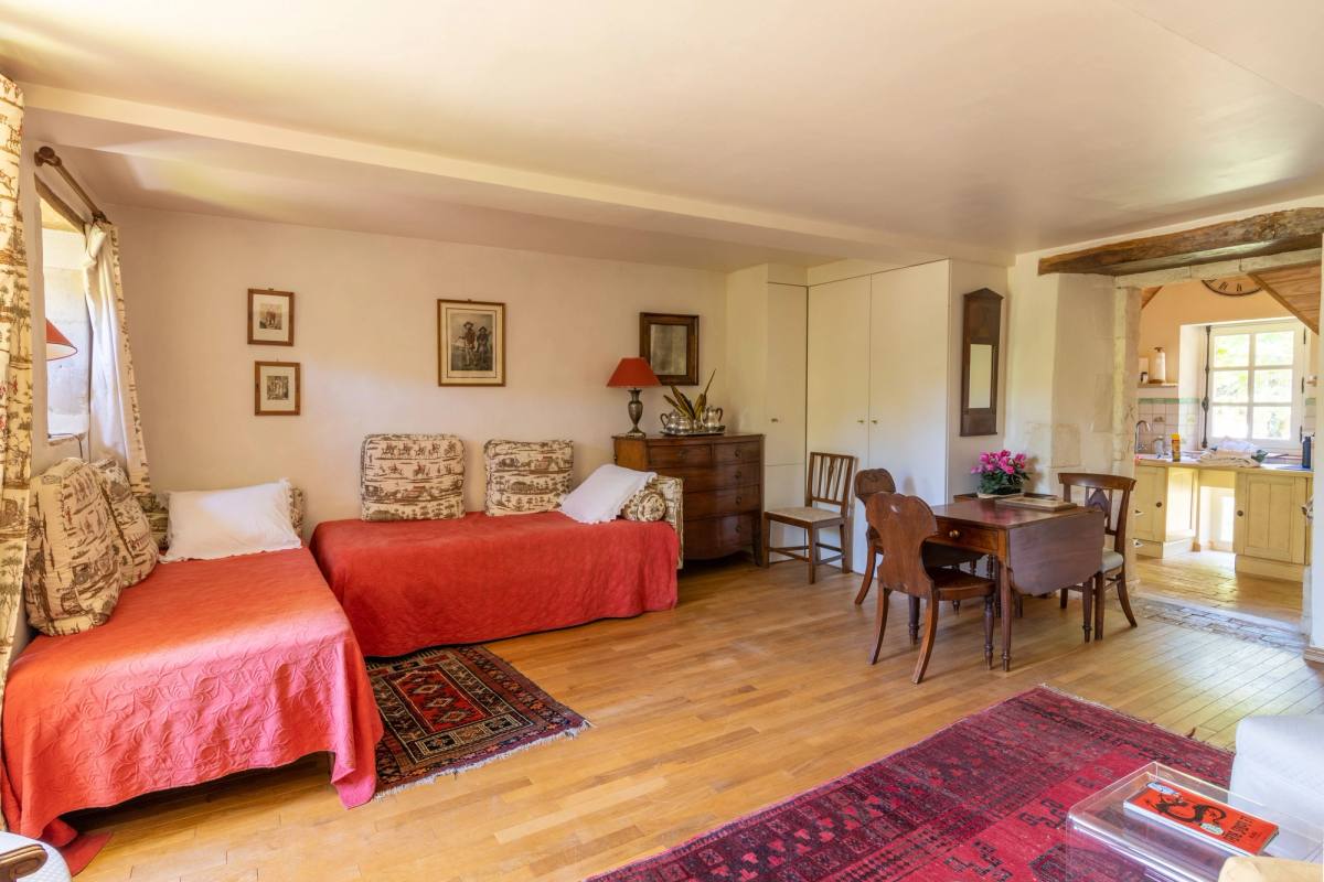 Gîte Les Lilas: living room with two single beds used as sofas and a dining table