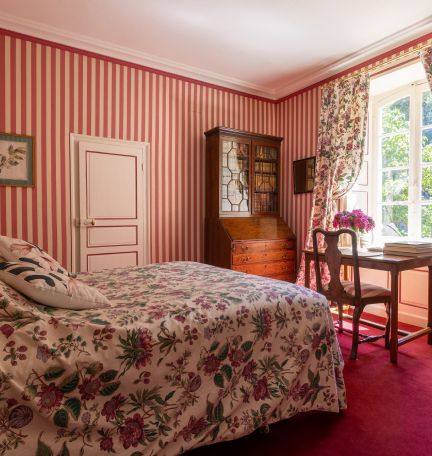 Chambre aux Fleurs: floral bed, secretary bookcase and a writing table by the garden window
