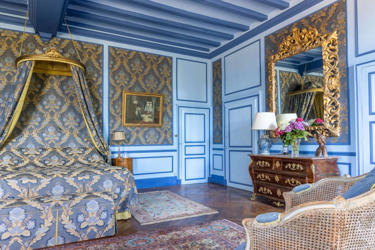 Canopy bed and bombé commode beneath a large gilded mirror, Suite Marin de Vanssay