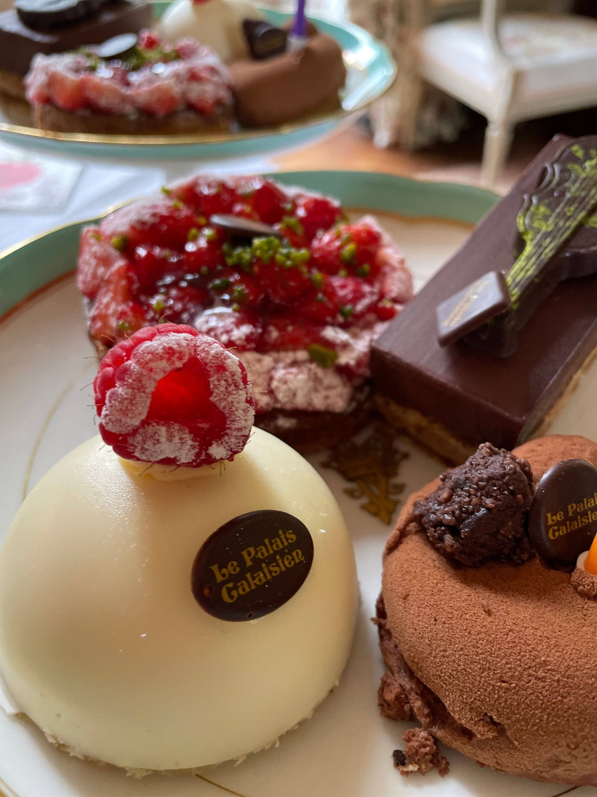Fine pâtisserie: a white dome topped with a raspberry, a red-fruit tart, chocolate slice and chocolate dome