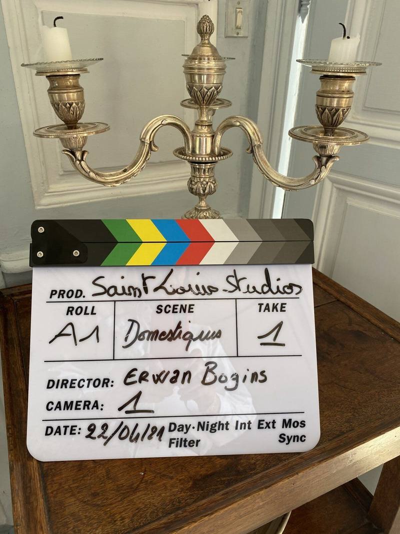Film clapperboard before a silver candelabra during a shoot at the château