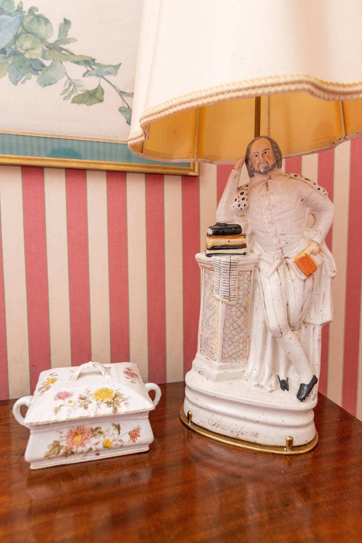 Chambre aux Fleurs: porcelain Shakespeare figure lamp beside a flowered lidded dish
