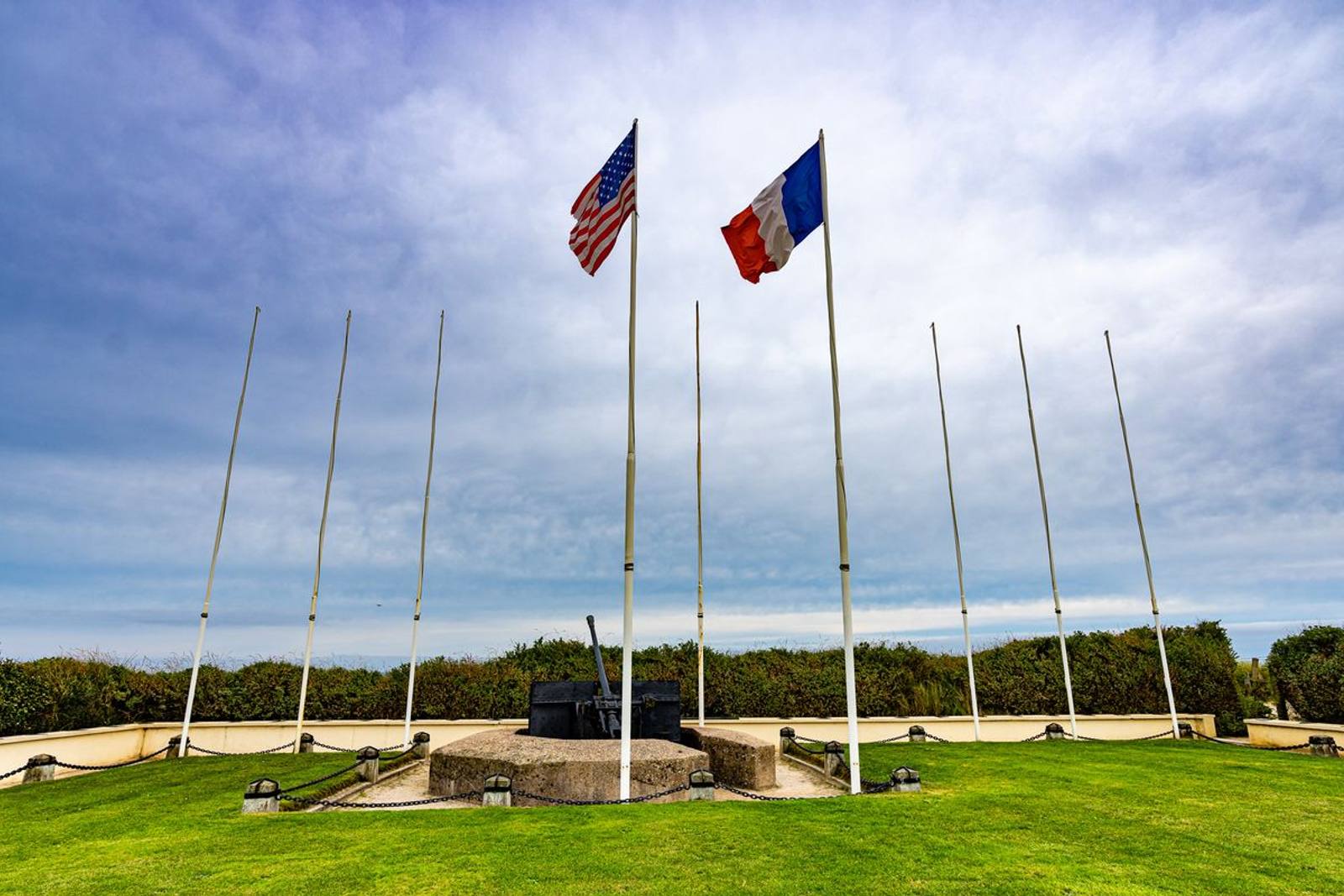 The American and French flags flying over the D-Day memorial at Pointe du Hoc, Normandy