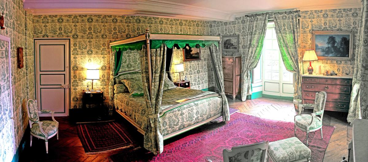 Chambre Esprit de Jouy Verte: four-poster bed in green toile de Jouy, red rugs, parquet floor