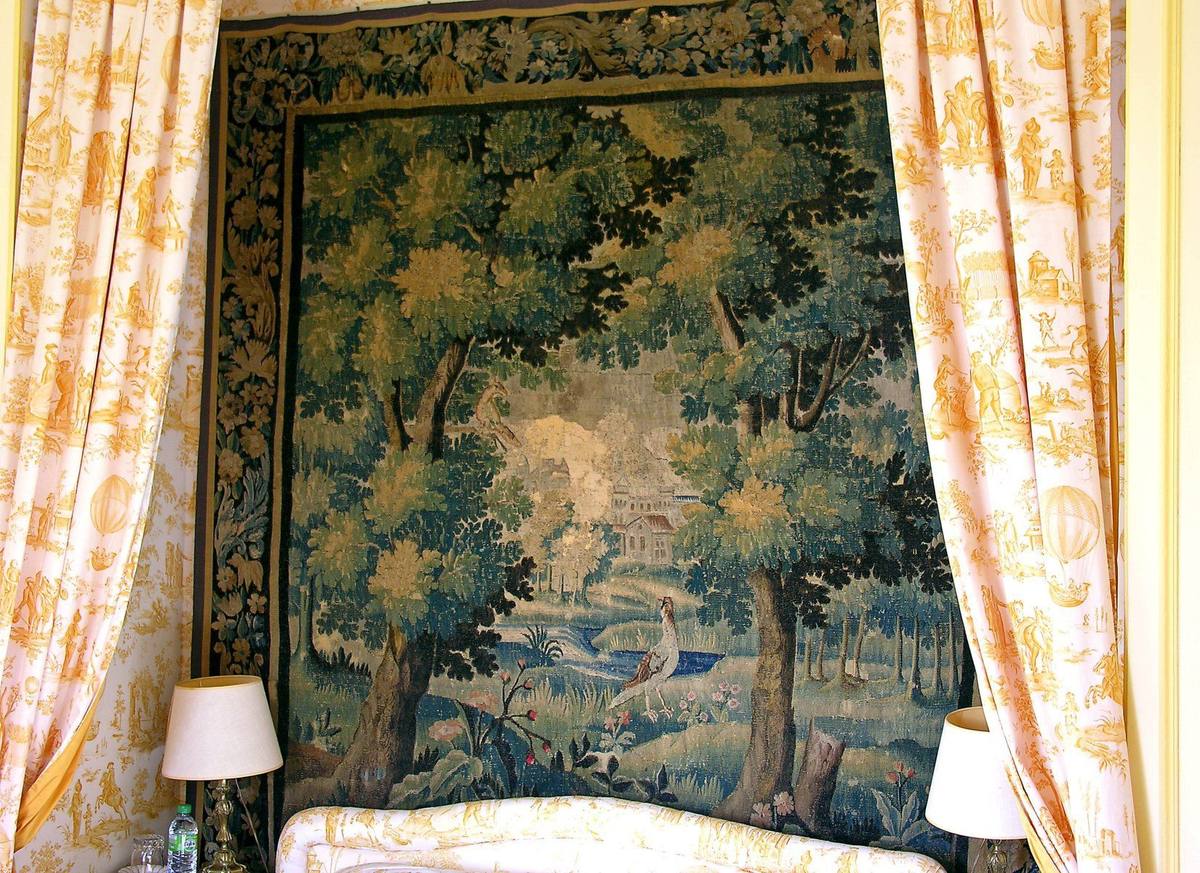 Verdure tapestry with trees and a bird behind the bed, framed by yellow toile curtains, Chambre Jaune