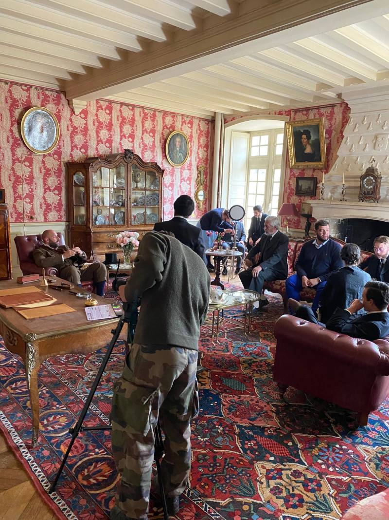 Film crew shooting a scene in the Salon Rose, cameraman on a tripod in the foreground
