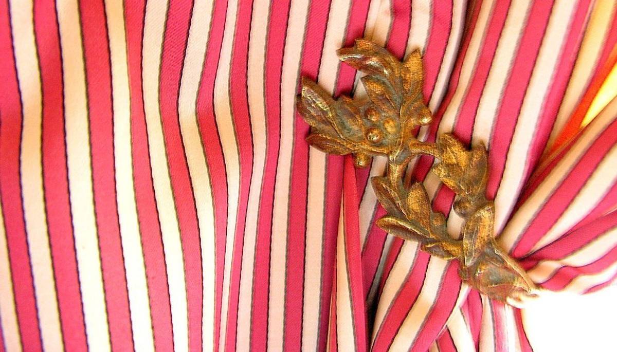 Red-and-white striped curtain gathered by a gilt-bronze leaf tieback, Directoire room