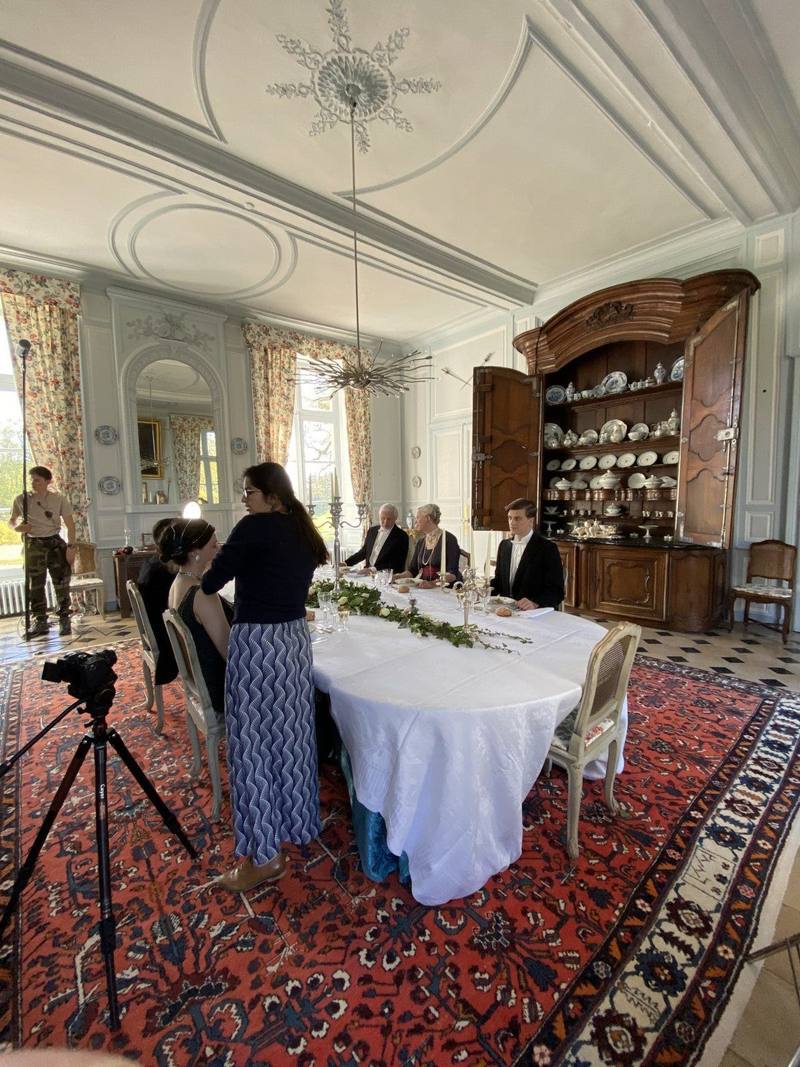 Film shoot in the Grande Salle à Manger: actors at a white-clothed table, camera on tripod