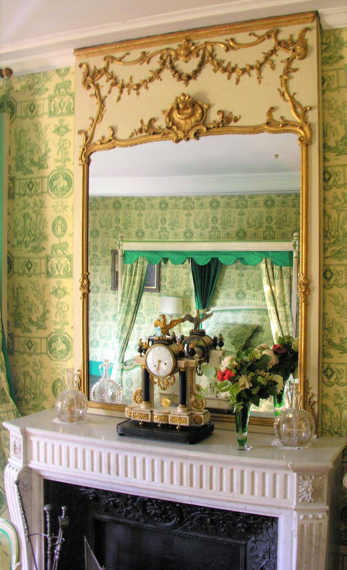Gilded trumeau mirror above a white marble fireplace with mantel clock, Chambre Esprit de Jouy Verte