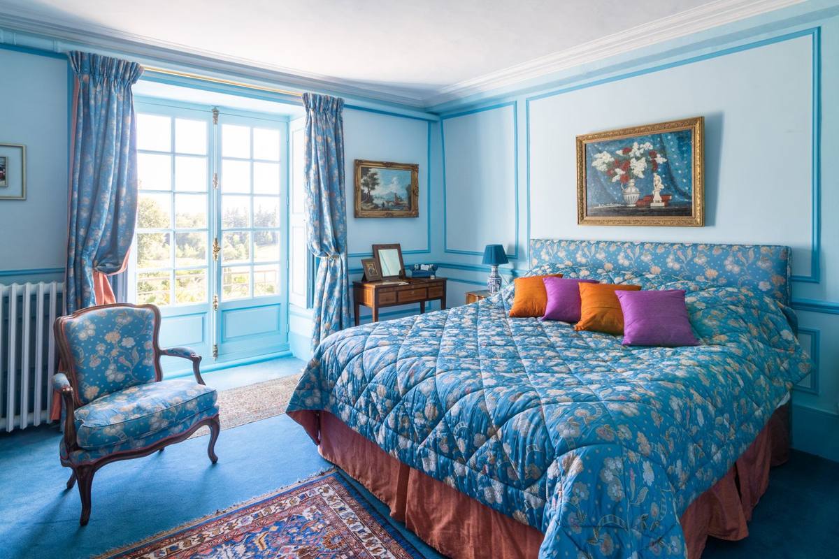 Chambre Turquoise: wide view with quilted bed, armchair and dressing table by the French window