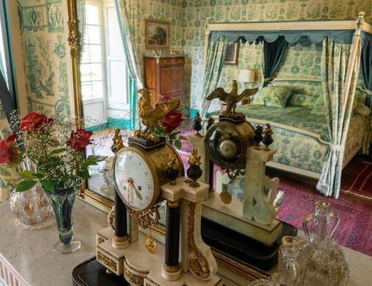 Mantel clocks and red roses, the canopy bed reflected in the mirror, Chambre Esprit de Jouy Verte