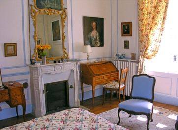 Chambre Louis XV: marble fireplace, gilt mirror, portrait, writing desk and blue armchair