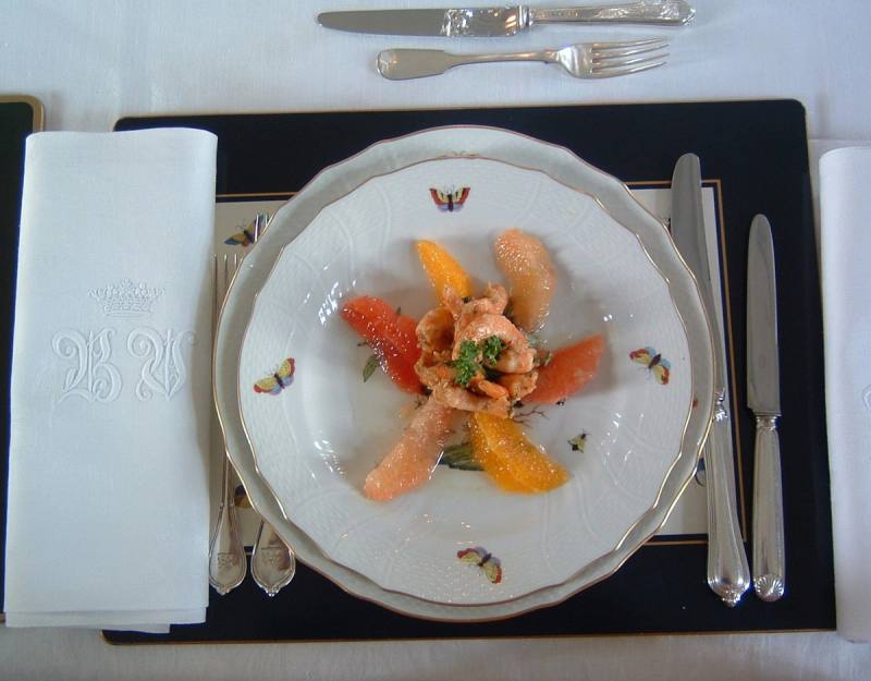 Starter of salmon and citrus segments on butterfly porcelain, with silver cutlery and monogrammed napkin