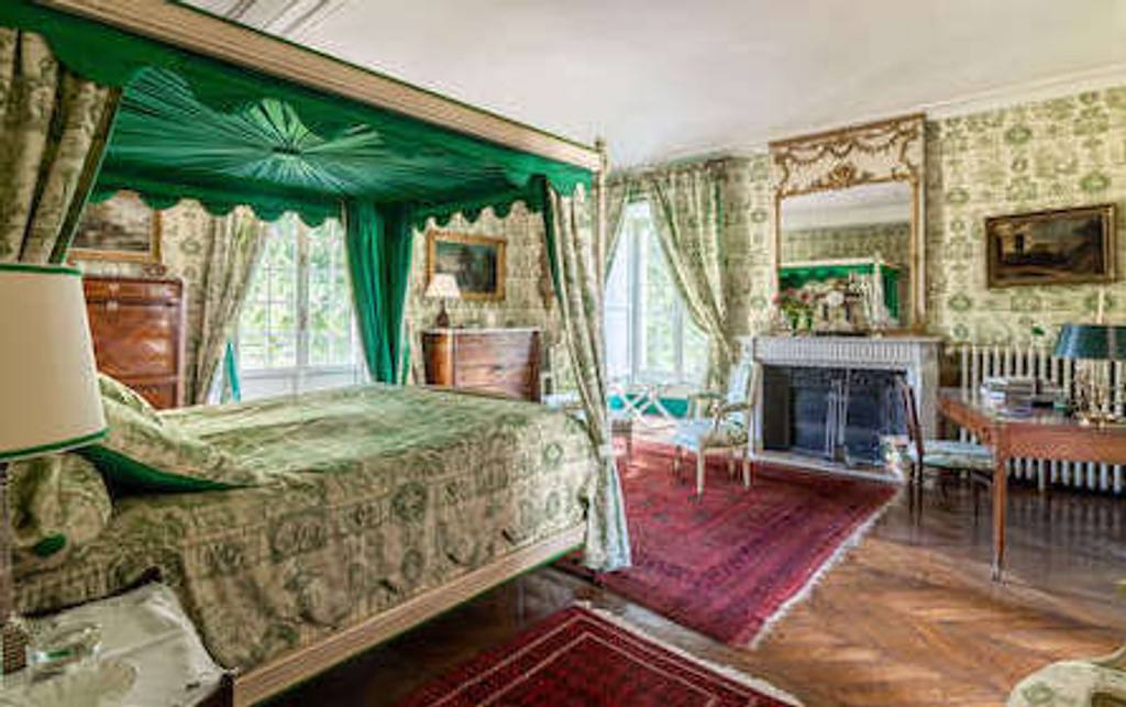 Chambre Esprit de Jouy Verte : lit à baldaquin drapé de vert, cheminée et murs en toile de Jouy