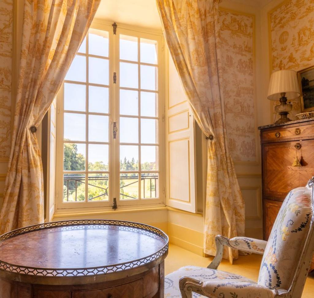 Tall window with yellow toile de Jouy curtains, gueridon table and armchair, Chambre Jaune