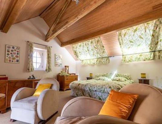 Gîte Les Lilas: attic bedroom with Art Deco armchairs, chest of drawers and double bed