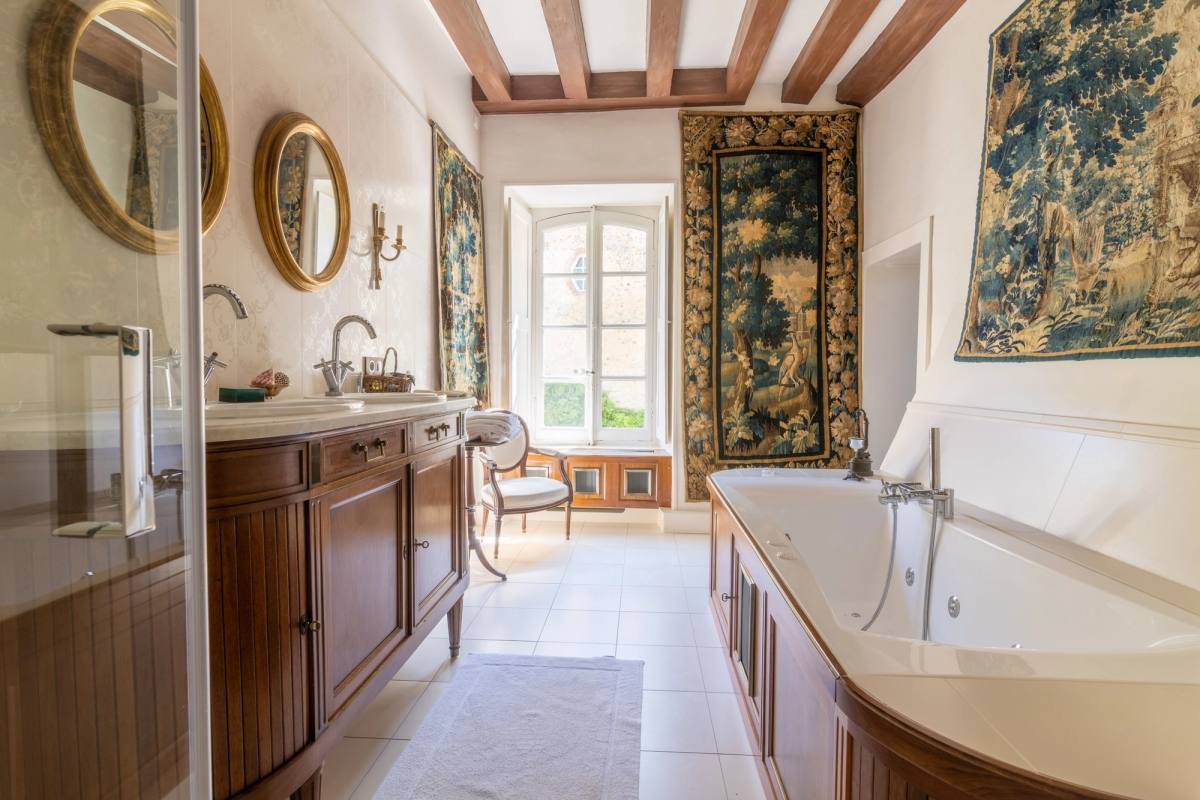 Bathroom of the Chambre Marin de Vanssay: tapestries, wooden vanity and large bathtub