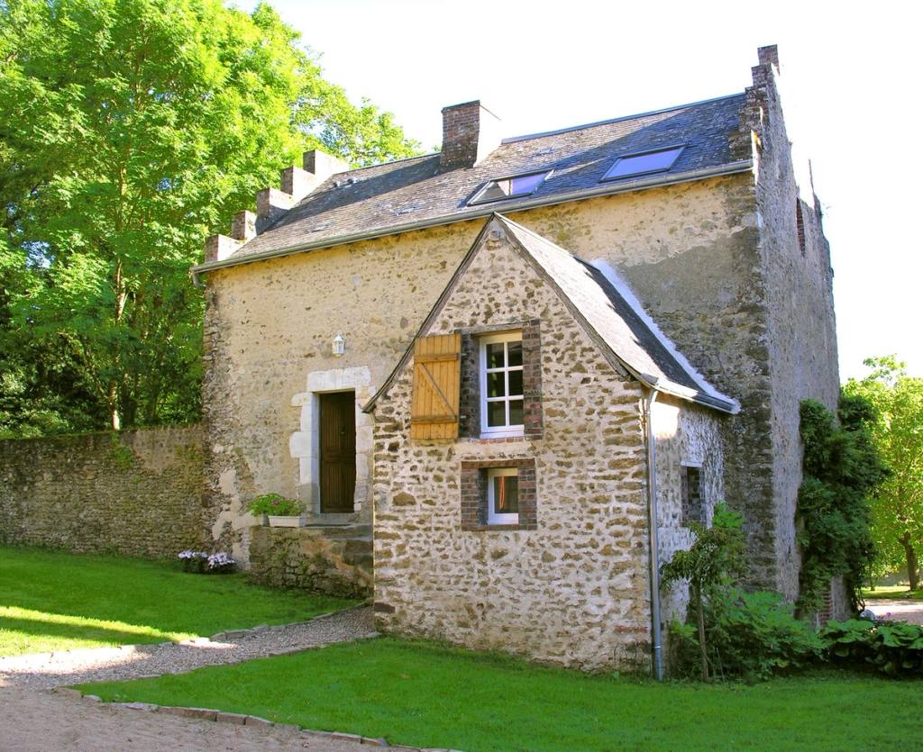 Stone outbuilding of the estate, north-west side, with a gabled wing and wooden shutter