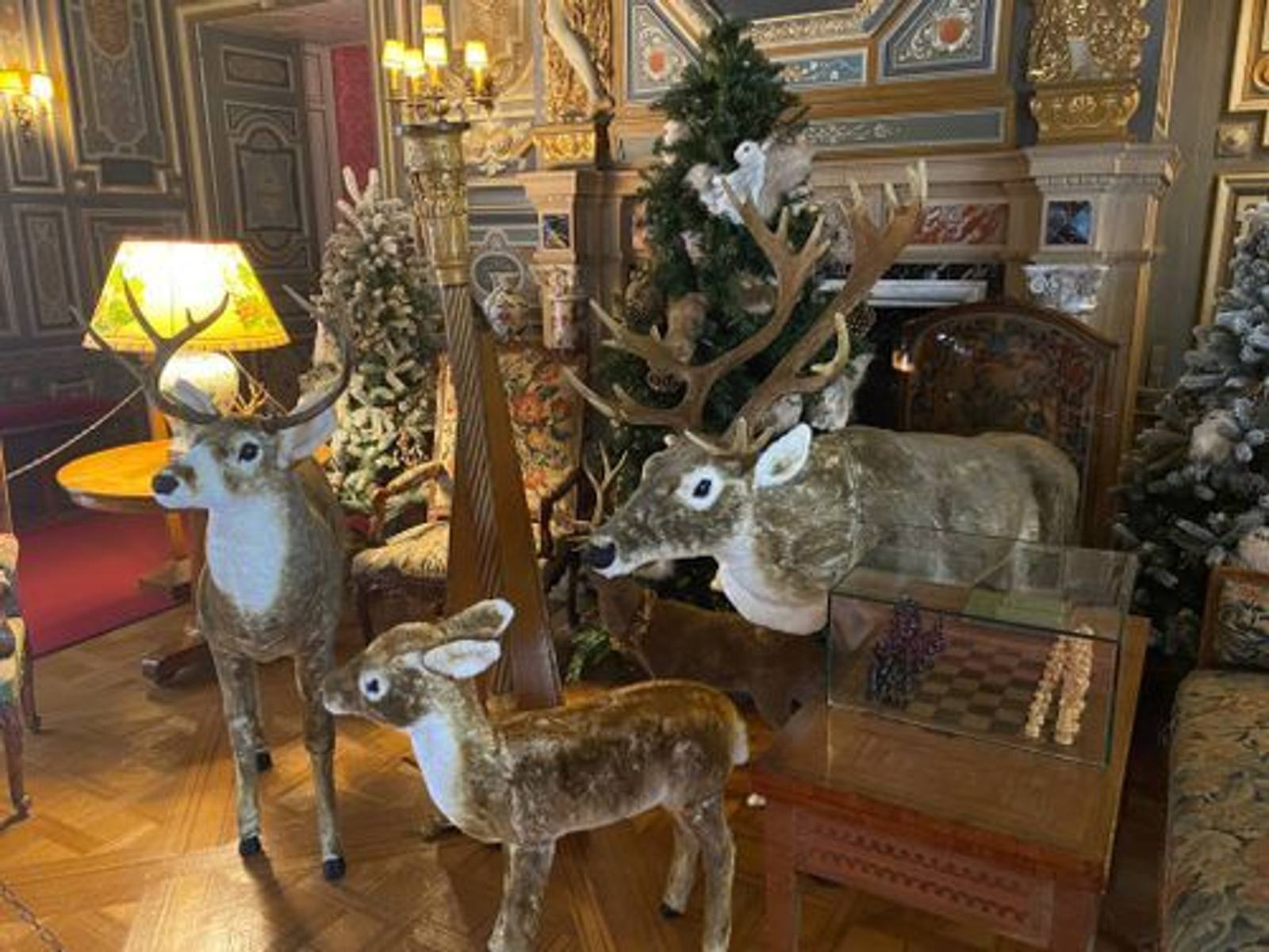 Reindeer figures and snow-dusted Christmas trees in a richly panelled salon, with a chessboard