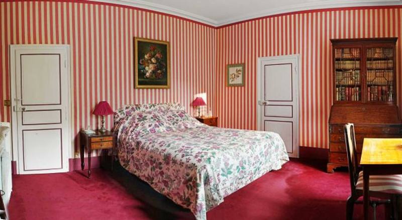 Chambre aux Fleurs: wide view of the floral bed, red carpet, striped walls and secretary bookcase