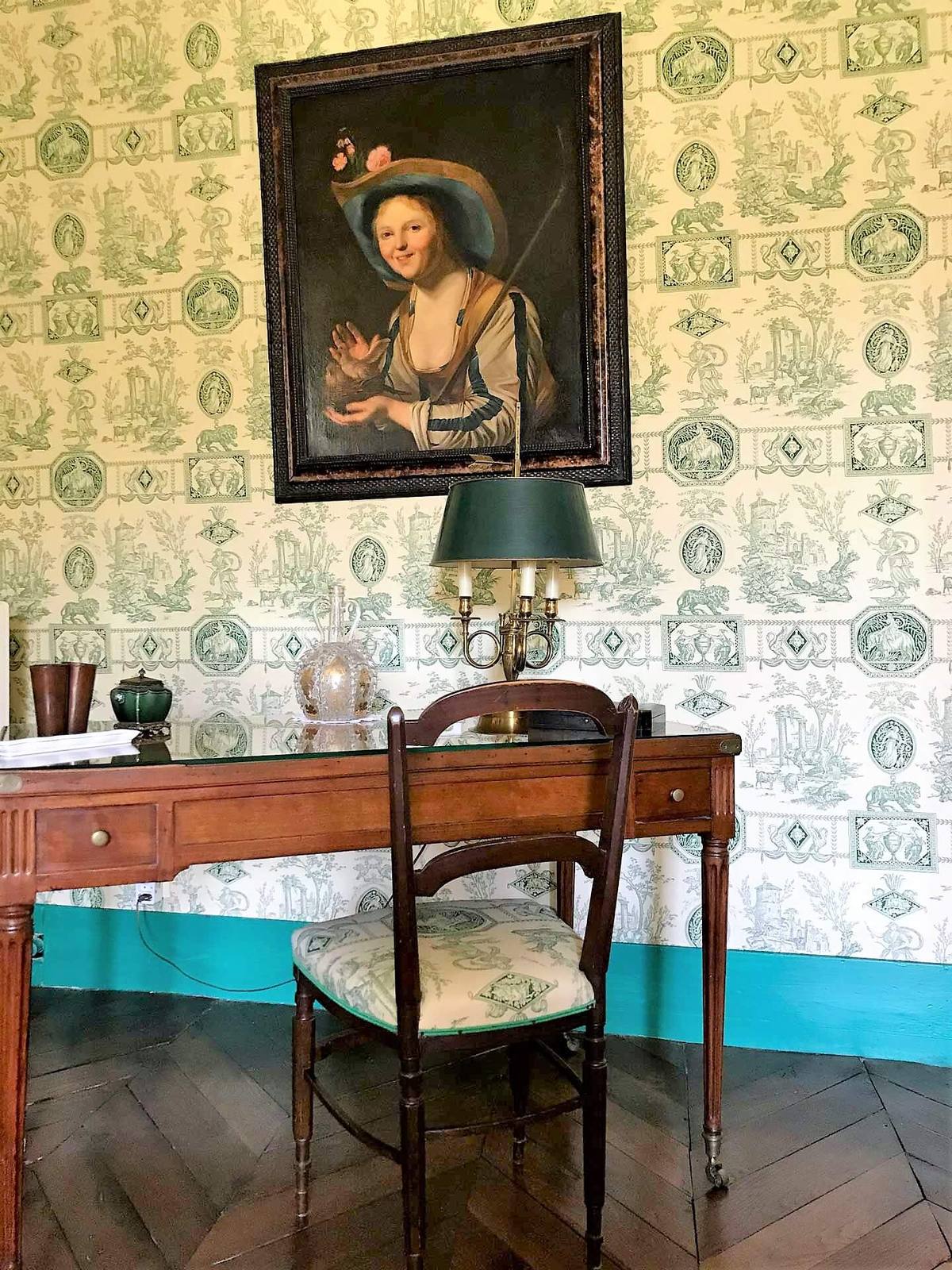Chambre Jouy Verte: writing desk beneath a portrait of a young woman, green toile de Jouy wallpaper