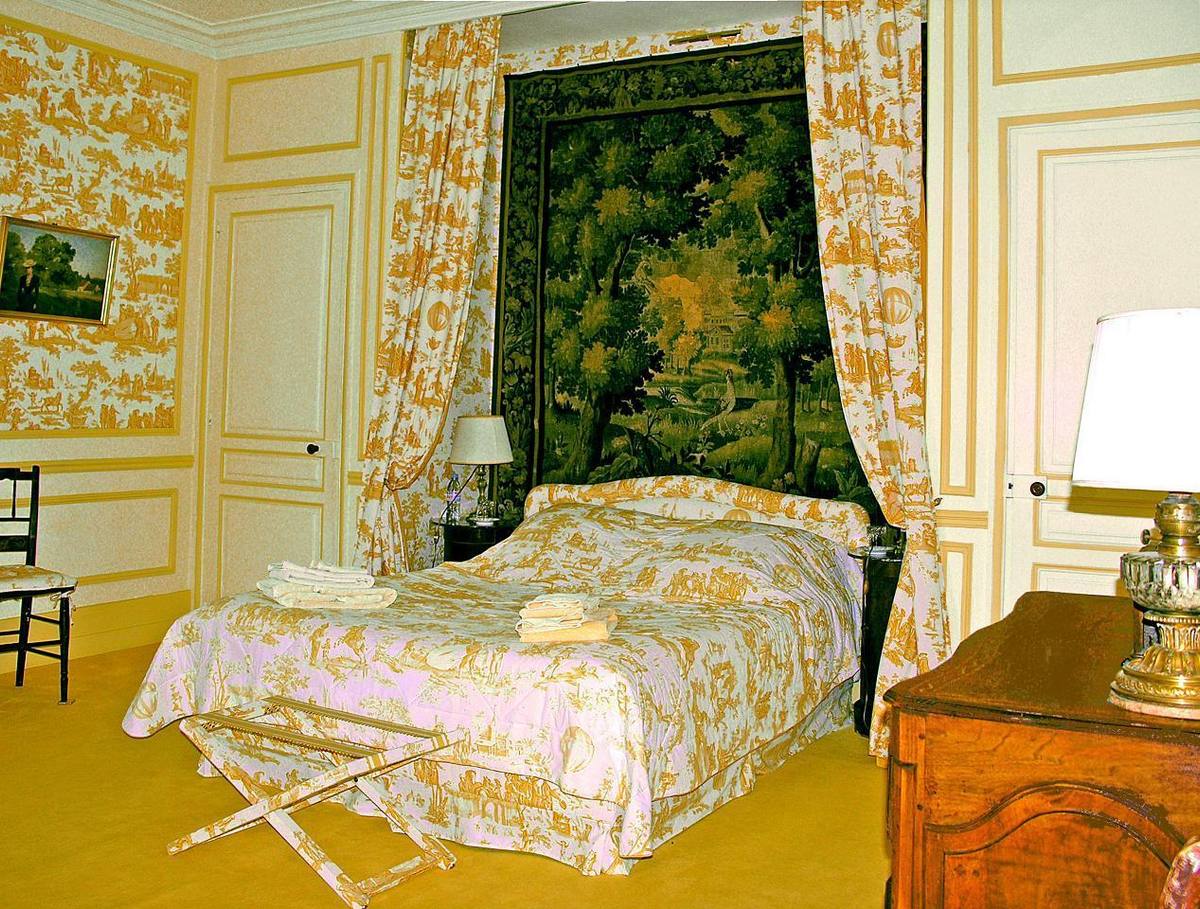 Chambre Jaune: bed beneath a green tapestry, yellow toile de Jouy curtains and walls