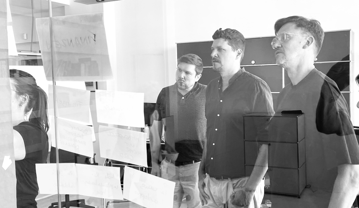 Team bei der agilen Zusammenarbeit in einem Softwareprojekt am Whiteboard mit Stickies