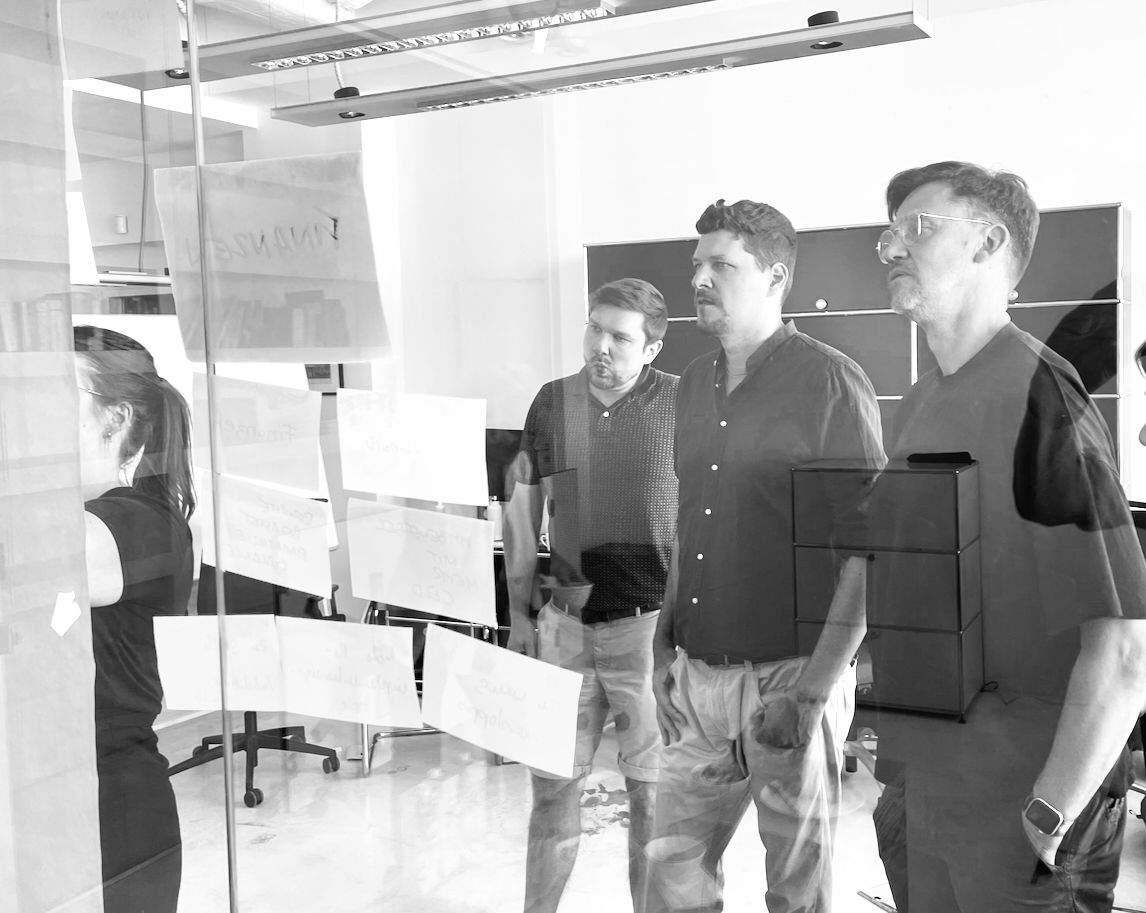 Foto aus einem Workshop. Nora heftet Notizzettel an ein Board.